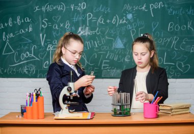 Bilimsel araştırmalar. Küçük bilim adamı mikroskopla çalışır. Okuldaki küçük kızlar. Resmi okul eğitimi. Biyoloji dersi. Kimya araştırması. Laboratuvarda bilimsel deneyler
