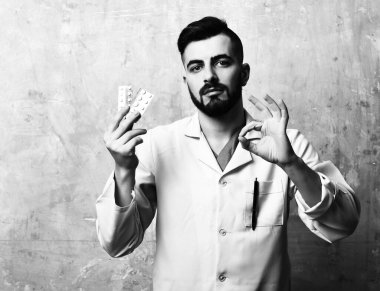 Sakallı ve şık saç kesimli doktor iyi bir jest yapıyor.