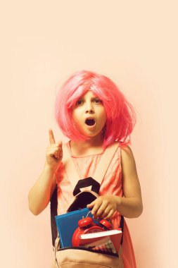 Çalar saati ve kitapları olan bir çocuk. Sırt çantalı kız.