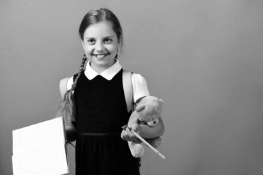 Okul üniformalı, örgülü ve sırt çantalı bir öğrenci.