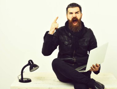 Masada dizüstü bilgisayarla oturan vahşi beyaz hippi.