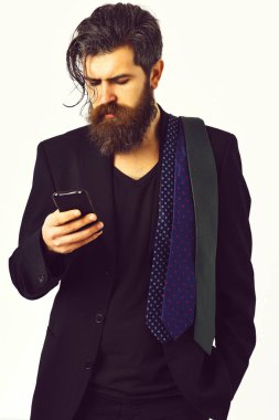 Beyaz stüdyo arka planında cep telefonu tutan Kafkasyalı bir hippi.