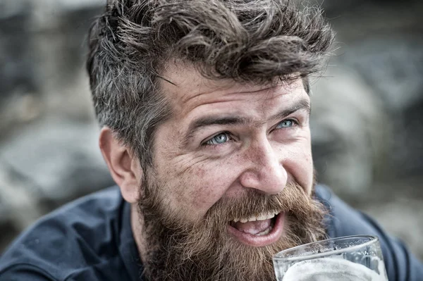 Człowiek z brodą i wąsami pije piwo, rozkojarzone tło. Koncepcja męskości. Hipster z rumianymi włosami i siwymi włosami, facet ze zmarszczkami na wesołej twarzy pijący napój ze szkła. — Zdjęcie stockowe