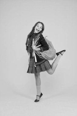 Güzellik bak. İngiltere 'deki İngiliz okulu. İngiltere 'de tatil. seyahat konsepti. Küçük kız üniforması. Sırt çantası. Ceketinde İngiliz bayrağı olan mutlu çocuk. İngiltere 'ye çalışmaya git. öğrenme dili