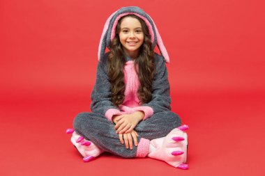 Mutlu çocuklar günü. Dinlen ve rahatla. Sevimli tavşan çocuk. Yavru hayvan karakteri. Tavşan kostümlü kız. Çocuk tavşan kigurumi. Mutlu kız tavşanlı pijama. Gülümseyen çocuk. Kıyafet dükkanı. Ev kıyafetleri.