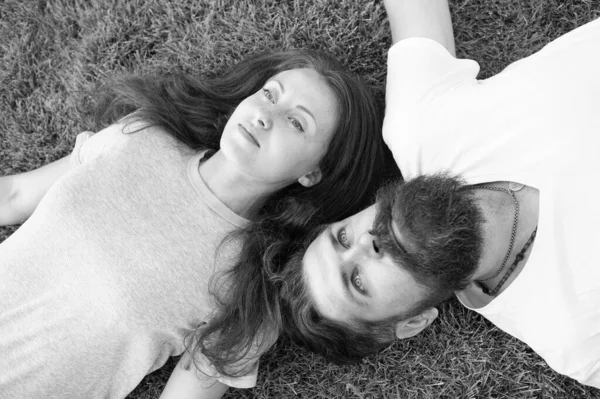 Couple reposent sur l'herbe verte. homme et femme se détendre en plein air. concept de rêve. Concept de rencontre. hipster barbu et fille insouciante. Jeunesse et liberté. Plus proche de la nature. couple se sentent libres. Fraicheur et paix — Photo