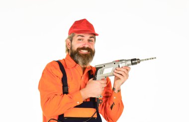 Güçlü matkap. Matkap al. Tamirci delik açıyor. Güvenlik önlemleri. Sondaj konsepti. Duvarı delmek için taş ustası olmak lazım. Beyaz arka planı delinmiş şapkalı bir adam. Perforatör ve bit