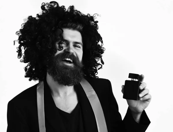 Hipster caucasien en costume et perruque bouclée noire tenant parfum — Photo