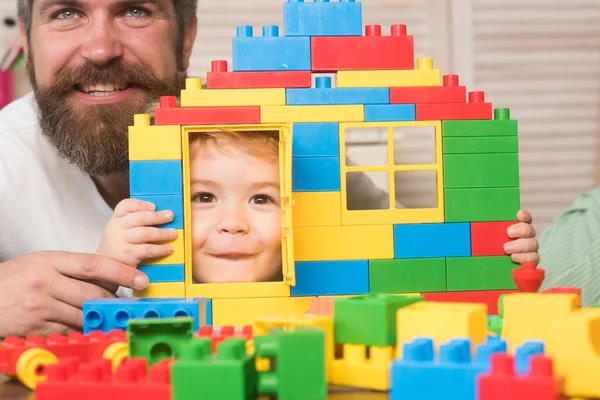 Çocuk plastik bloklardan yapılmış evin kapısından bakıyor.. — Stok fotoğraf