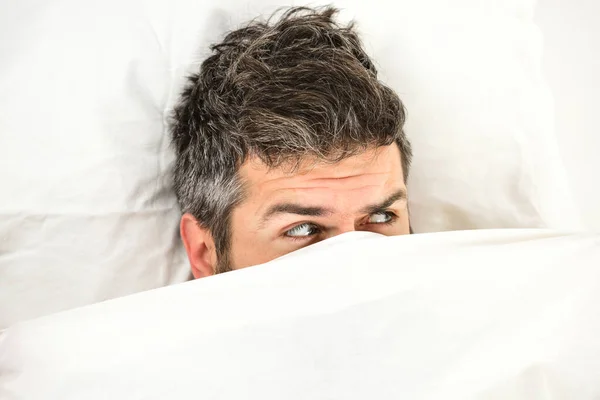 Man wants to stay in bed, white background,