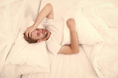 Yatakta aktiviteleri kısıtla. Adam uykusuz bir gece geçirmiş. Erkek sağlığı konsepti. Barışseverlik kavramı. Yorgun adam yatakta uyuyor. Sabah erken kalktım. Adam beyaz yatak odasında uyuyor. Evde rahat bir hafta sonu. Dinlenme zamanı.