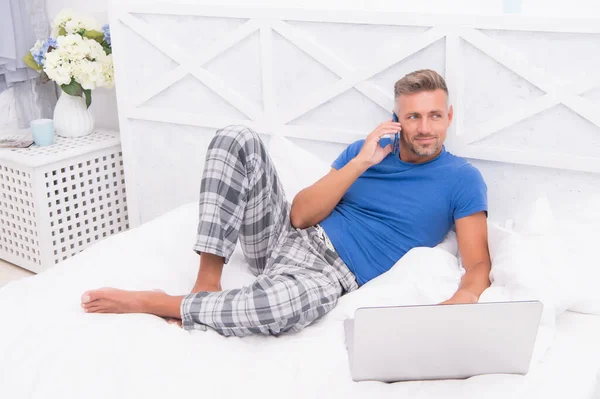 Nätverk på datorn. Frilans från hemmet. Distansarbete i karantän. Snygg man kommunicerar på laptop. använda telefonen före sömnen. man bloggare använder internet-teknik — Stockfoto