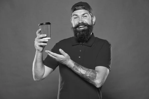 C'est délicieux. prendre le café ici. meilleure qualité de café service trucs. Bonjour café à emporter. homme barbu boire thé fond rouge. Un hipster brutal en uniforme. heureux barista tenir tasse de café — Photo