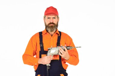 Bir şeye çarpmadan duvarı delmeyi. Beyaz arka planı delinmiş şapkalı bir adam. Tamirci delik açıyor. Güvenlik önlemleri. Sondaj konsepti. Perforatör ve ısırık. Güçlü matkap. Matkap al