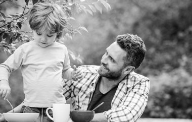 Sağlıklı yemek ve diyet. Çocuklar Günü 'nde. Yaz pikniği. Sabah kahvaltısı. Baba oğul dışarıda yemek yiyorlar. Babalar günün kutlu olsun. Babasıyla küçük çocuk mısır gevreği yiyor. Aile yemeği zamanı. Mutlu bir aile olduğumuz için