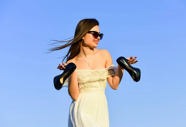 Libertad. Chica en gafas de sol copiar espacio. Modelo tierno vestido de verano. Hacia el verano. Concepto post fiesta. Mujer amanecer llevar tacones altos en la mano. Mujer en el soleado cielo azul de la mañana. Vacaciones de verano — Foto de Stock