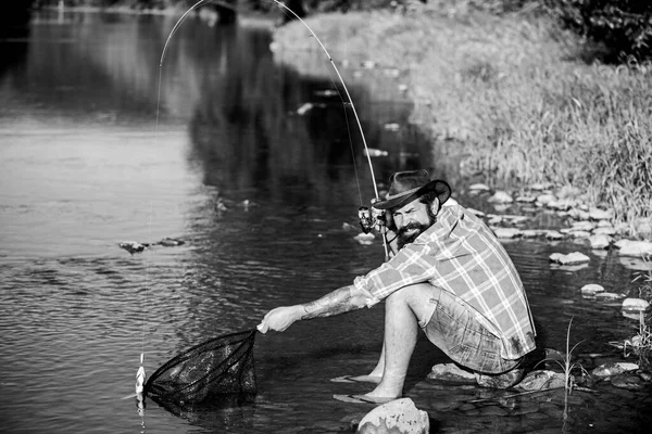 Χόμπι για ψυχή. Ο άνθρωπος στην όχθη του ποταμού απολαμβάνει γαλήνιο ειδυλλιακό τοπίο ενώ ψαρεύει. Ενωμένοι με τη φύση. Η τεχνική ψαρέματος ψαράδων χρησιμοποιεί καλάμι. Ο άνθρωπος πιάνει ψάρια. Ο τύπος πετάει για ψάρεμα. Επιτυχής αλιεία μύγας — Φωτογραφία Αρχείου