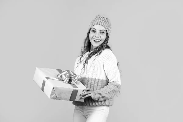 Feliz Navidad y Felices Fiestas. Felices vacaciones de invierno. alegre niña tejida sombrero y suéter. niño mantenga presente caja de fondo amarillo. regalo de Navidad venta de compras. que tu navidad sea brillante —  Fotos de Stock