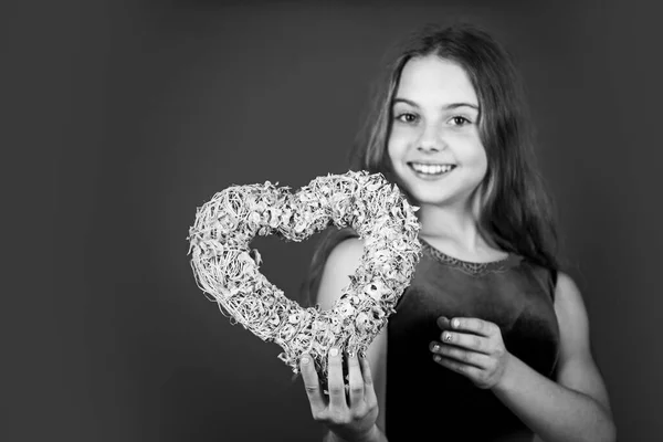 Creas mi sonrisa de corazón. Niño feliz con el corazón rojo de fondo. Niña con corazón de mimbre rosa. Decoración en forma de corazón para el día de San Valentín. Vacaciones de amor y cuidado, espacio de copia — Foto de Stock