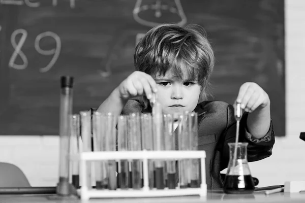 Egy kisfiú mikroszkóppal az iskolában. Egy kisfiú a tudományos táborban. A diák tudományos kísérleteket végez mikroszkóppal a laborban. mikroszkóp a laborban. Mi tűnik problémának? — Stock Fotó