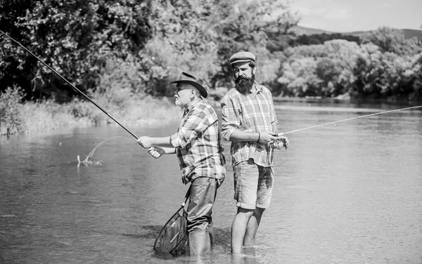 Padre e figlio pescano. Famiglia di pescatori. Hobby attività sportive. Weekend estivo. Attivita 'pacifica. Bella presa. Asta e placcaggio. Attrezzatura da pesca dei pescatori. Pescatore nonno e maturo uomo amici — Foto Stock