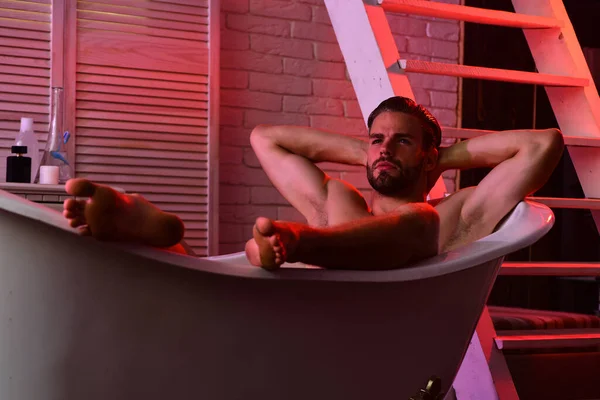 Concept Erotica : macho assis dans la baignoire avec des lumières rouges allumées — Photo