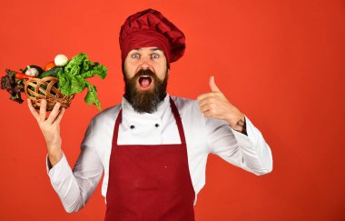 Şefin elinde marul, domates, biber ve sarımsak var. Sakallı adam