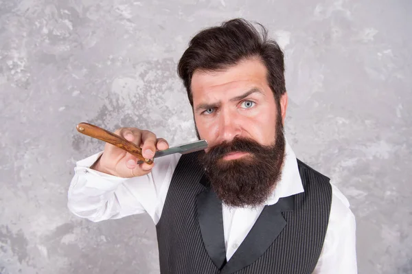 Profesyonel ekipmanlar. Kuaför salonu. Saç sakalı bakımı. Saçlarını tıraş eden yakışıklı, vahşi bir adam. Tımar rutini. Yüz bakımı. Düz jilet, sapına kadar kıvrılabilen bıçaklı jilettir. Tıraş Adam