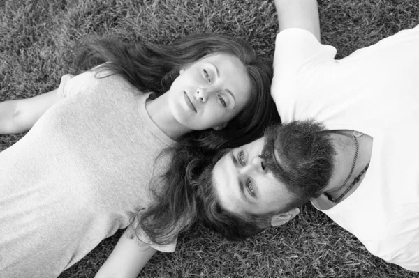 Man and woman relax outdoor. dreaming concept. Dating concept. brutal man and girl carefree. Youth and freedom. Closer to nature. couple feel free. couple lie on green grass. Relax on spring grass — Stock Photo, Image