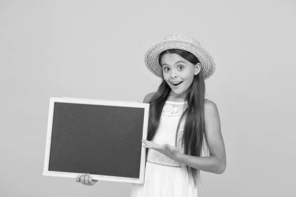 学校のためにこの製品が必要です。幸せな女の子製品を提示する。小さな子供は学校の黒板を持っている。販売のための製品。製品プロモーション。広告テキスト、コピースペースのための空の黒板 — ストック写真