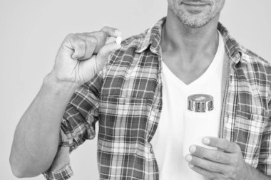 Erkek uyuşturucu kavanozu. Tıraşsız bir adam vitamin hapı kutusunu tutar. Tıp konsepti. anabolik ve steroidler. Erkek sağlığı için gıda katkı maddeleri. Biyolojik vitamin kompleksi. Hastalık tedavisi. Ürünü sunuyorum.