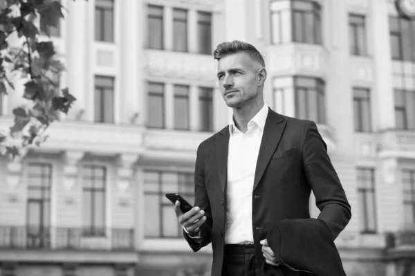 Confident man formal outfit. modern life concept. businessman on way to office. agile business. use phone while walking. urban style and everyday life. ordinary working day. charismatic man in suit — ストック写真