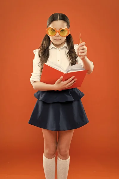 inspiration for writing. get information from book. happy school girl in uniform and party glasses. small child with notebook. literature lesson education. writing in workbook. children literature