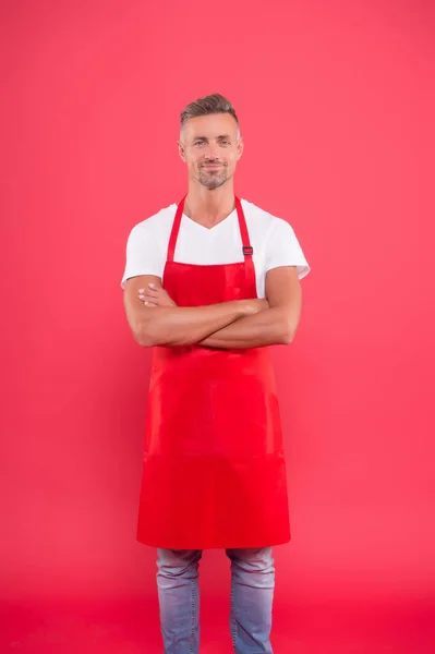 Gästfri och självsäker make. man i förkläde i köket. Snygg vaktmästare bär uniform för städning. vänlig leende bartender. Professionell städning. hushåll och människor koncept — Stockfoto