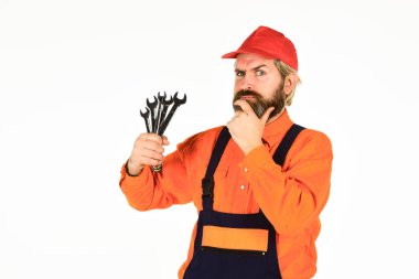 Otomotiv Teknisyenleri ve Tamircileri. Anahtar aracı sıkılaştırıcı detayları düzeltiyor. Profesyonel aletler. Değiştirme parçaları. Adam anahtar aletlerini tutuyor. Sorunu doğru ve hızlı bir şekilde teşhis et. İngiliz anahtarı aracı