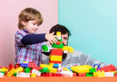 Baba ve çocuk plastik bloklar inşa ediyor. Çocuk bakımı ve yetiştirme. Baba oğul oyunu. Baba ve oğul inşaatlar yaratıyor. Sakallı adam ve oğlu birlikte oynuyorlar. Oğlunla bağ kurmanın kesin yolları.