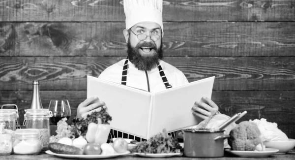 Esta receta es perfecta. Hombre barbudo hipster leer libro receta cerca de verduras frescas de mesa. Artes culinarias. Receta para cocinar alimentos saludables. Receta vegetariana. Chef experimentado cocina excelente plato — Foto de Stock