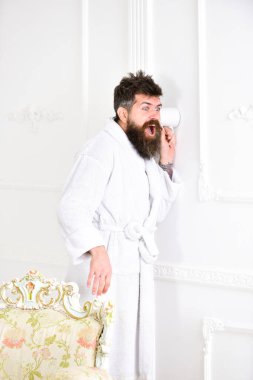 Sakallı ve bıyıklı bir adam duvarın yanında bardak kullanarak kulak misafiri oluyor. Heyecanlı yüzlü, bornozlu hippi gizlice konuşmayı dinler. Beyaz içerideki adam casusluk yapıyor, gizlice dinliyor. Mahremiyet ve gizli konsept.