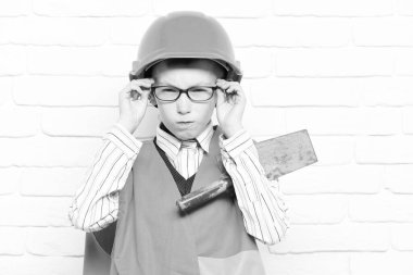 Beyaz tuğladan duvar altyapısı olan yakışıklı bir çocuk.