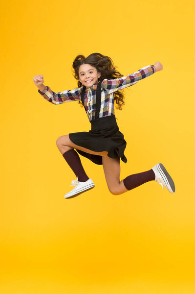 Be happy everyday. Happy child in midair yellow background. Having fun. Happy childhood. Raising happy kid. School holidays. International childrens day