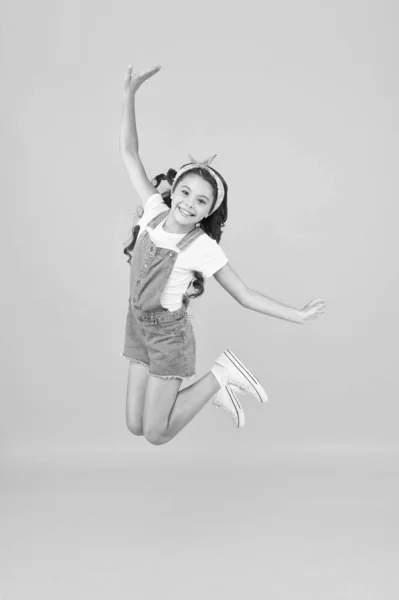 Small girl jump yellow background. Enjoy freedom. Childrens day concept. Spirit of freedom. Active girl feel freedom. Fun and relax. Feeling free. Carefree kid. Summer holidays. Jump of happiness — Stock Photo, Image