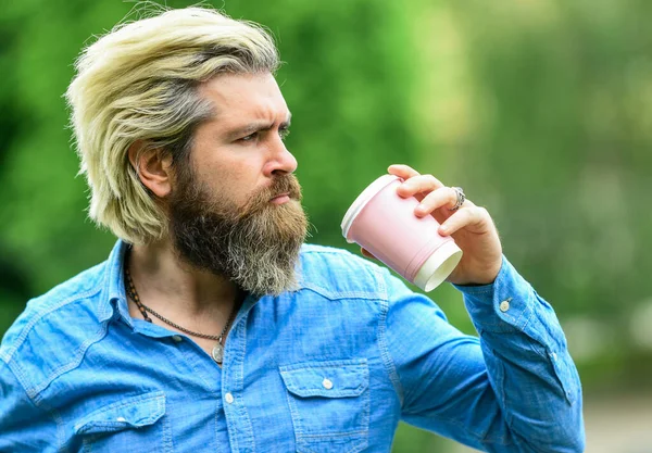 Good start of the morning. man with a cup of coffee outdoors. Handsome calm bearded man outdoors with a cup of coffee. Man drinking hot coffee. tourist relaxing in park drink tea. Coffee on the go