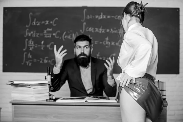 Allettante e seducente. Una donna seducente che seduce un uomo a scuola. Studente sexy in gonna rossa seducente. Usando tattiche di seduzione in classe. Sexi donna con sguardo seducente stuzzicare uomo barbuto — Foto Stock