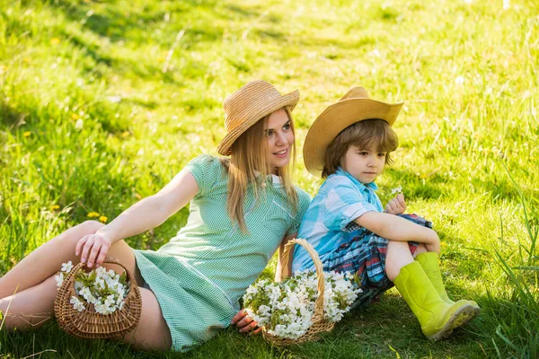 Mère et fils se détendent. Vacances de printemps. Bonnes vibrations. La saison du printemps. Amour et respect de la patrie. Loisirs week-end. Explorez la nature. Joyeuses fêtes. Famille Cowboy collectionnant des fleurs printanières. Eco-vie — Photo