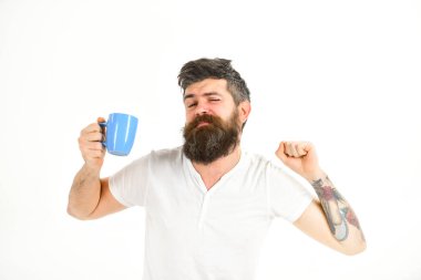 Sakallı uykucu hippi elinde kupa tutuyor..