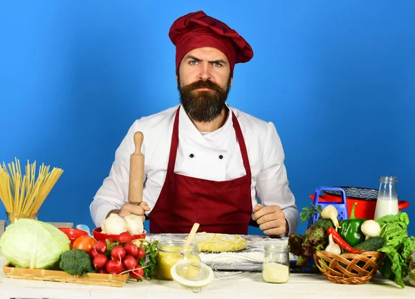 Cook med allvarligt ansikte i vinröd uniform håller rullande stift — Stockfoto