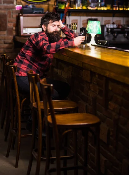 Man with tired face sit in bar or pub