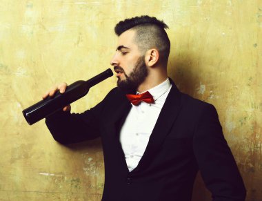 Yorgun yüzlü genç klas adam alkollü içecek içiyor.