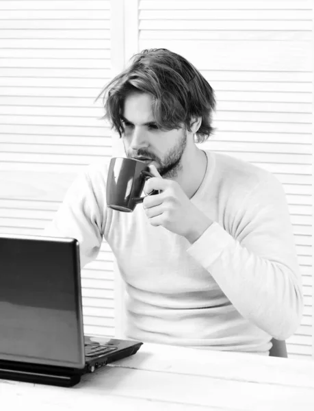 Man at his working place with gadget and tea cup