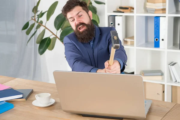 Das System hinkt. Büroroutine hassen. Mann mit Bart zerquetscht Computer. Softwarelizenzvereinbarung. Laptop zerstören. Verhasste Arbeit. Schlechter Computer. Langsame Internetverbindung. Veraltete Software. Computerverzug — Stockfoto